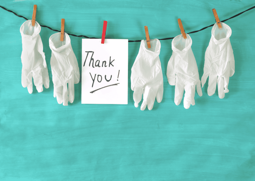 gloves hanging on a clothes line with a thank you note